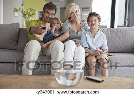 Couple watching television with their sons View Large Photo Image Stock Image - Couple watching television with their sons. Fotosearch