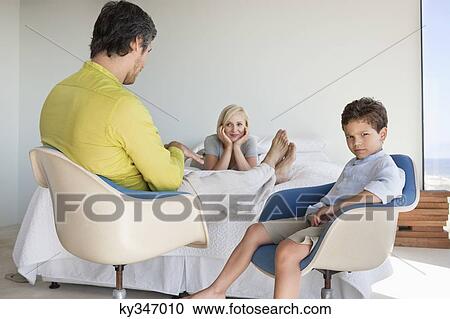 Couple with their son talking in a bedroom View Large Photo Image Stock Image - Couple with their son talking in a bedroom. Fotosearch