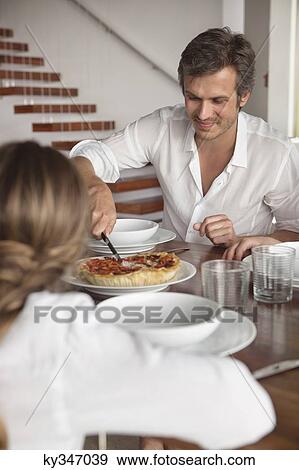 Man having food with his daughter View Large Photo Image Stock Photo - Man having food with his daughter. Fotosearch