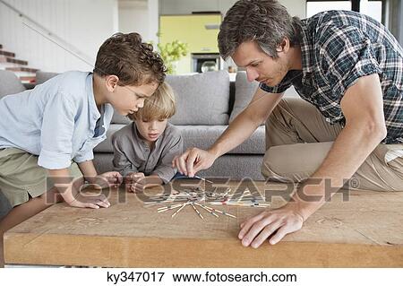 Man playing pick up sticks with his sons View Large Photo Image Stock Photo - Man playing pick up sticks with his sons. Fotosearch