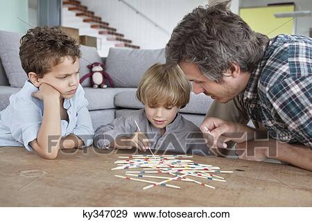 Man playing pick up sticks with his sons View Large Photo Image Stock Photo - Man playing pick up sticks with his sons. Fotosearch