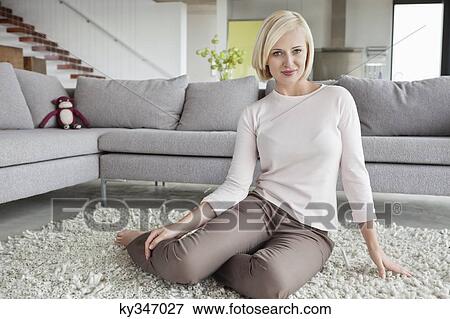 Portrait of a woman sitting on carpet View Large Photo Image Stock Photo - Portrait of a woman sitting on carpet. Fotosearch