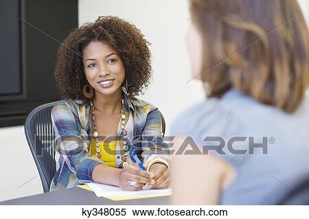 Stock Photography - African American woman taking an interview of a woman. Fotosearch