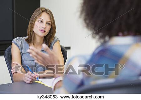 Stock Image - Businesswoman taking an interview of an African American woman. Fotosearch
