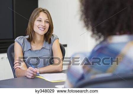 Businesswoman taking an interview of an African American woman View Large Photo Image Stock Photo - Businesswoman taking an interview of an African American woman. Fotosearch