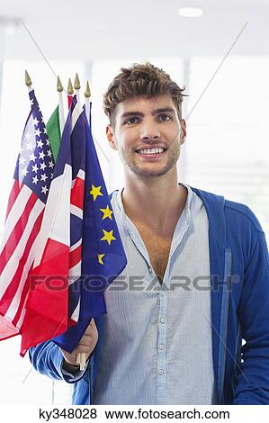 Portrait of a man holding flags of various countries at an airport View Large Photo Image Stock Photo - Portrait of a man holding flags of various countries at an airport. Fotosearch