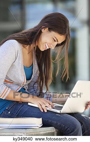 Close-up of a smiling woman using a laptop View Large Photo Image Stock Image - Close-up of a smiling woman using a laptop. Fotosearch