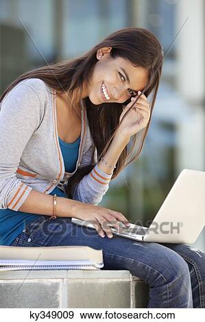 Stock Photo - Portrait of a smiling woman using a laptop. Fotosearch