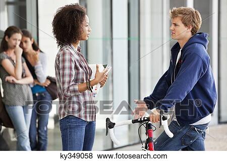 Stock Photo - Two friends discussing in campus. Fotosearch
