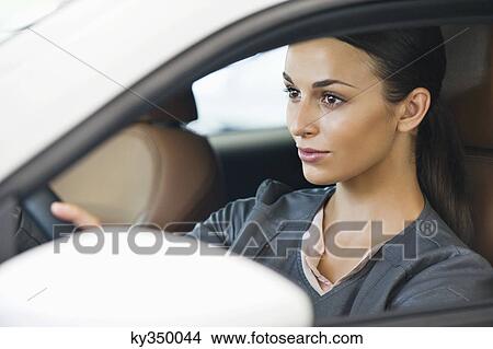 Beautiful young woman taking a test drive View Large Photo Image Picture - Beautiful young woman taking a test drive. Fotosearch