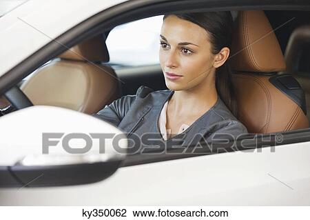 Beautiful young woman taking a test drive View Large Photo Image Stock Image - Beautiful young woman taking a test drive. Fotosearch