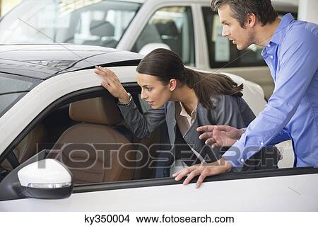 Couple examining a car before buying View Large Photo Image Picture - Couple examining a car before buying. Fotosearch