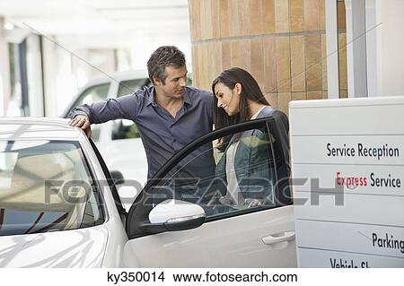 Couple looking inside car at showroom View Large Photo Image Picture - Couple looking inside car at showroom. Fotosearch