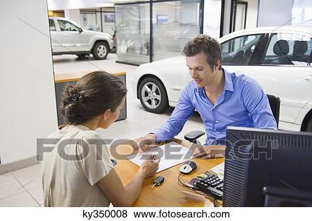 Mid adult man buying car in a showroom View Large Photo Image Stock Photo - Mid adult man buying car in a showroom. Fotosearch