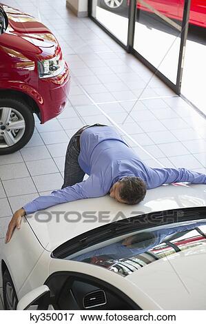 Mid adult man hugging the hood of a car View Large Photo Image Stock Photo - Mid adult man hugging the hood of a car. Fotosearch