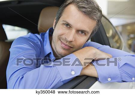 Portrait of a happy mid adult man leaning on car window View Large Photo Image Stock Photo - Portrait of a happy mid adult man leaning on car window. Fotosearch