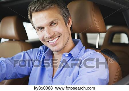 Portrait of a happy mid adult man taking a test drive View Large Photo Image Stock Photo - Portrait of a happy mid adult man taking a test drive. Fotosearch