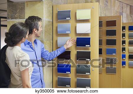 Rear view of a couple looking at color samples at car showroom View Large Photo Image Stock Photography - Rear view of a couple looking at color samples at car showroom. Fotosearch