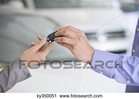 Salesman handing car key to woman View Large Photo Image Stock Image - Salesman handing car key to woman. Fotosearch