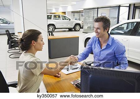 Saleswoman shaking hands with her customer View Large Photo Image Stock Photo - Saleswoman shaking hands with her customer. Fotosearch