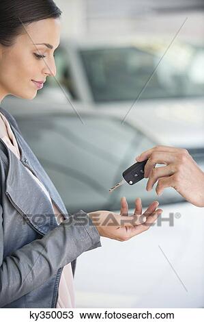 Side profile of a young woman taking car key in showroom View Large Photo Image Stock Image - Side profile of a young woman taking car key in showroom. Fotosearch