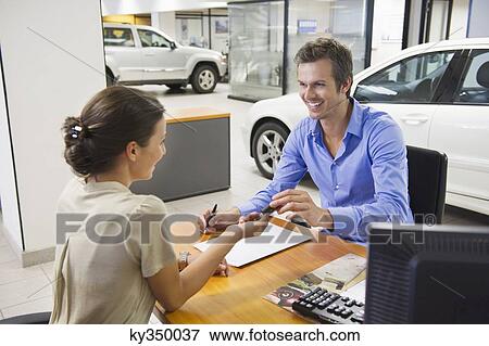 Young woman handing car key to a man View Large Photo Image Stock Photo - Young woman handing car key to a man. Fotosearch
