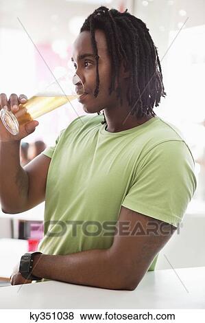 Man drinking beer at a bar View Large Photo Image Stock Photo - Man drinking beer at a bar. Fotosearch