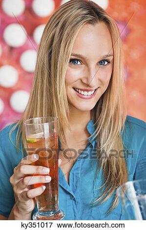 Portrait of a beautiful woman having ice tea in a bar and smiling View Large Photo Image Stock Photo - Portrait of a beautiful woman having ice tea in a bar and smiling. Fotosearch