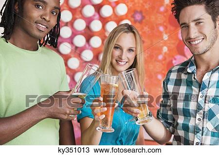 Portrait of friends toasting drinks at a bar View Large Photo Image Stock Image - Portrait of friends toasting drinks at a bar. Fotosearch