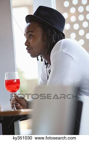 Young man having red wine at a bar View Large Photo Image Stock Image - Young man having red wine at a bar. Fotosearch
