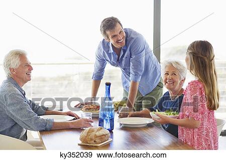 Multi generation family eating food at a dining table View Large Photo Image Stock Photo - Multi generation family eating food at a dining table. Fotosearch