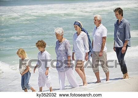 Multi generation family walking in a line on the beach View Large Photo Image Stock Image - Multi generation family walking in a line on the beach. Fotosearch