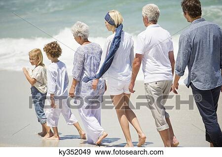 Multi generation family walking in a line on the beach View Large Photo Image Stock Photo - Multi generation family walking in a line on the beach. Fotosearch