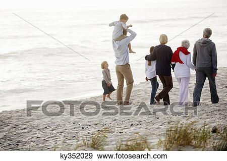 Multi-generation family walking on the beach View Large Photo Image Stock Photo - Multi-generation family walking on the beach. Fotosearch