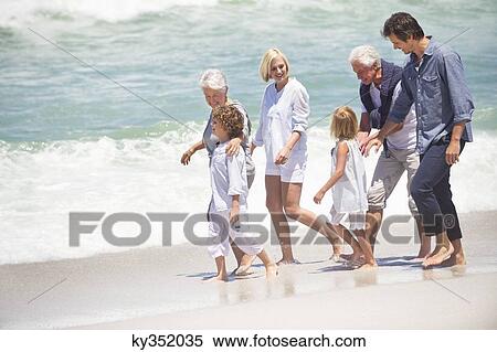 Stock Photography - Multi-generation family walking on the beach. Fotosearch