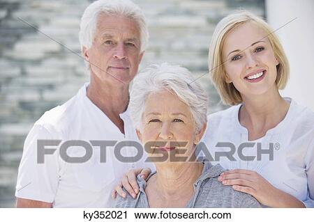 Stock Image - Young woman smiling with her parents. Fotosearch