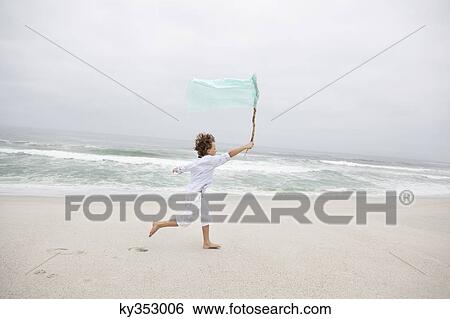 Beautiful view of beach with boy running View Large Photo Image Stock Photograph - Beautiful view of beach with boy running. Fotosearch