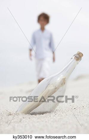 Blurred boy walking towards bottle with note inside on beach View Large Photo Image Stock Image - Blurred boy walking towards bottle with note inside on beach. Fotosearch