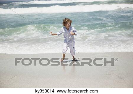 Boy playing on beach View Large Photo Image Picture - Boy playing on beach. Fotosearch