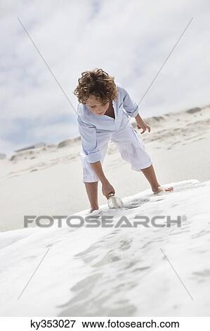 Boy putting bottle with message in water on beach View Large Photo Image Stock Photo - Boy putting bottle with message in water on beach. Fotosearch