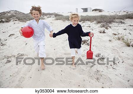 Children holding toys and running on sand View Large Photo Image Picture - Children holding toys and running on sand. Fotosearch