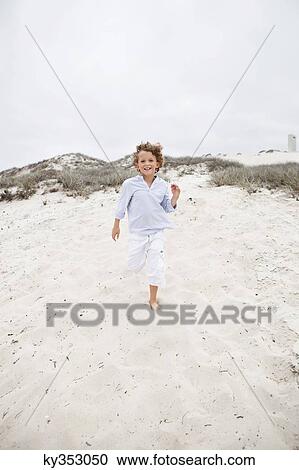 Cute boy running on sand at beach View Large Photo Image Stock Image - Cute boy running on sand at beach. Fotosearch