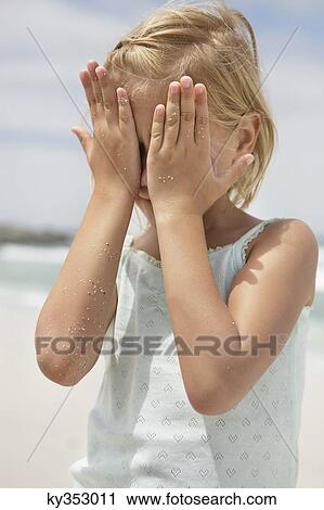 Stock Image - Girl covering her face with hands. Fotosearch