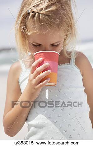 Stock Photography - Girl drinking from disposable glass. Fotosearch