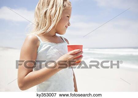 Girl holding a disposable glass on the beach View Large Photo Image Stock Photo - Girl holding a disposable glass on the beach. Fotosearch
