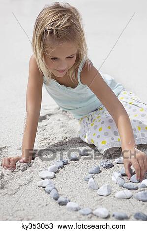 Girl playing with pebbles on beach View Large Photo Image Stock Image - Girl playing with pebbles on beach. Fotosearch