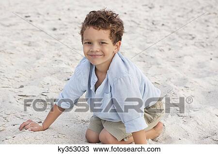 Portrait of a boy playing on sand View Large Photo Image Stock Image - Portrait of a boy playing on sand. Fotosearch