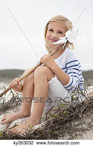 View of girl holding pinwheel and contemplating View Large Photo Image Stock Image - View of girl holding pinwheel and contemplating. Fotosearch