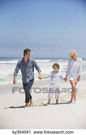 Boy walking with his parents on the beach View Large Photo Image Stock Image - Boy walking with his parents on the beach. Fotosearch