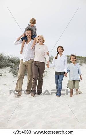 Couple walking on the beach with their children View Large Photo Image Stock Image - Couple walking on the beach with their children. Fotosearch